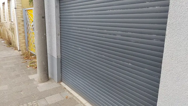 Fragen Garagentor Reparatur: Rolltor aus Aluminium an einer Hausfassade