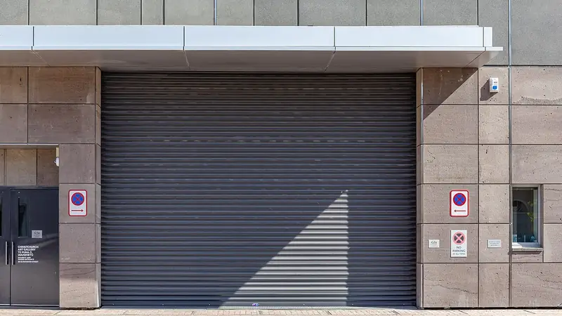 Graues Rolltor einer Tiefgarageneinfahrt